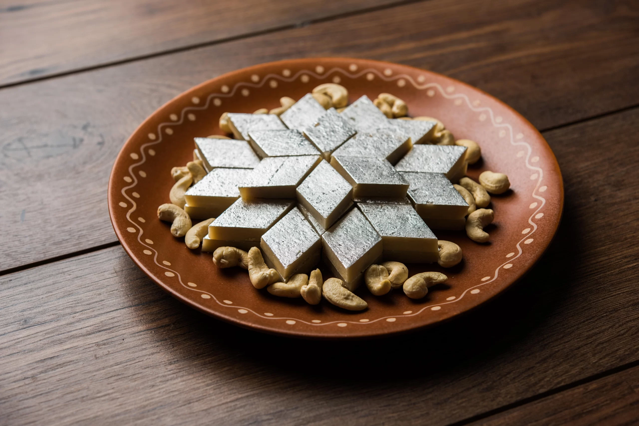 kaju-katli-is-diamond-shape-indian-sweet-made-using-cashew-sugar-mava-served-plate-moody-surface-selective-focus-min